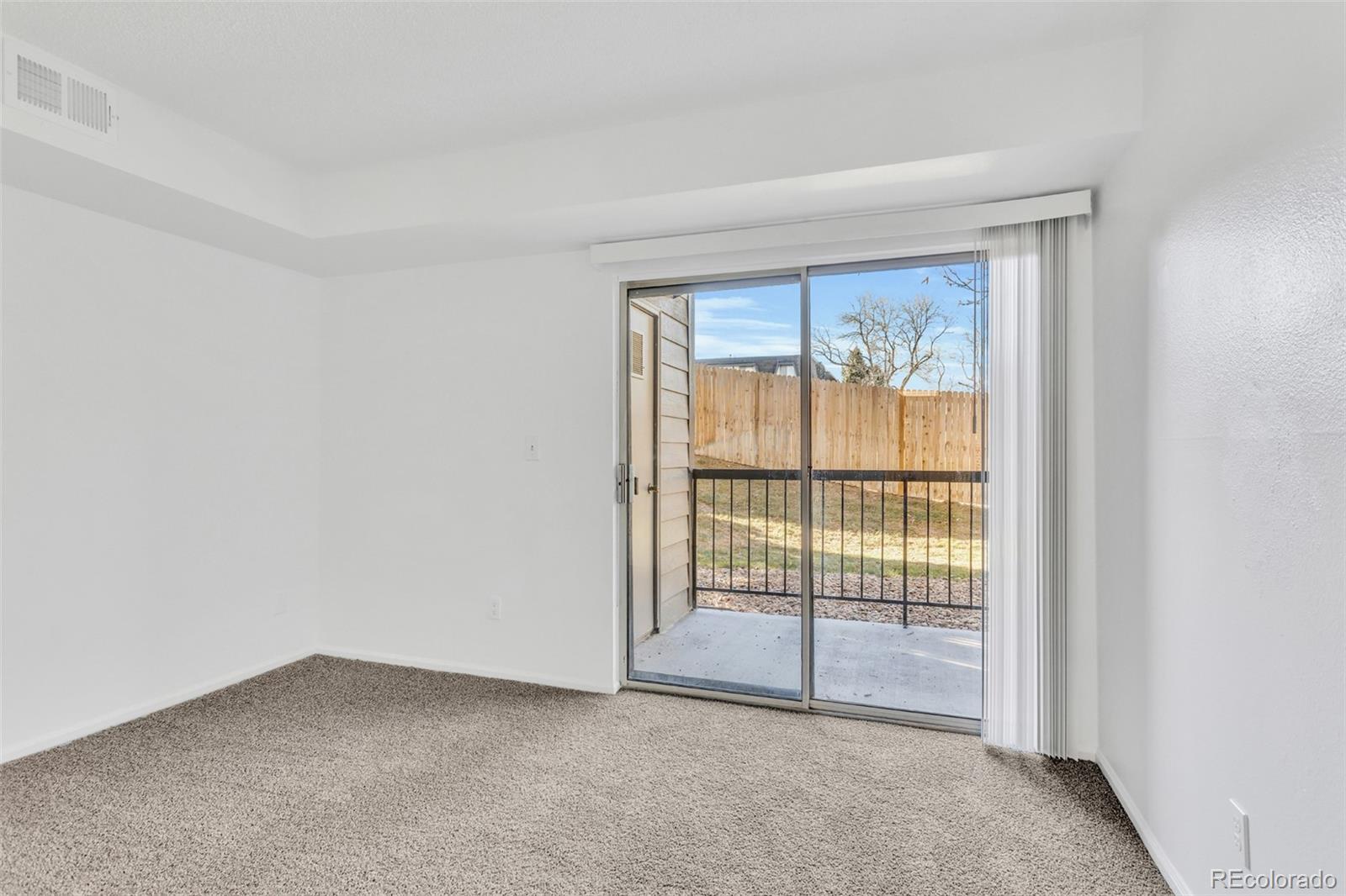 2575 South Syracuse Way, Unit J108 Denver, CO 80231 - Photo 12 of 18 a view of an empty room with glass door