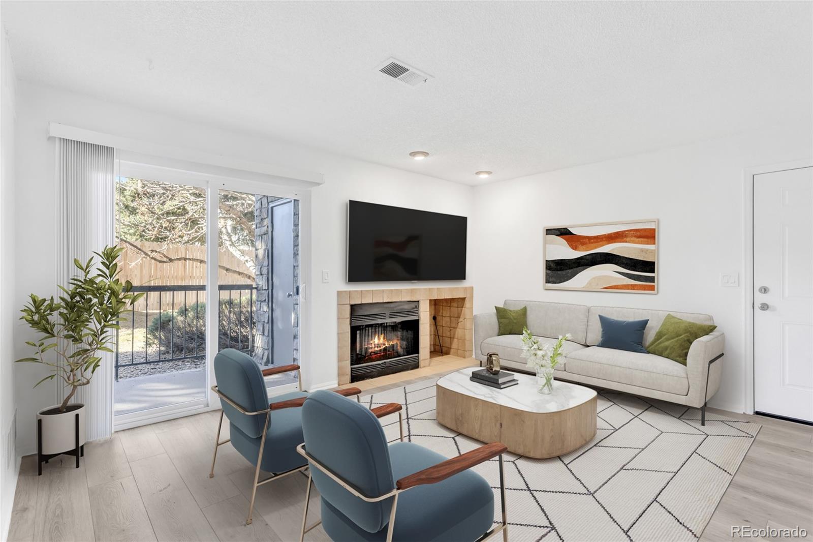 2575 South Syracuse Way, Unit J108 Denver, CO 80231 - Photo 2 of 18 a living room with furniture a fireplace and a flat screen tv