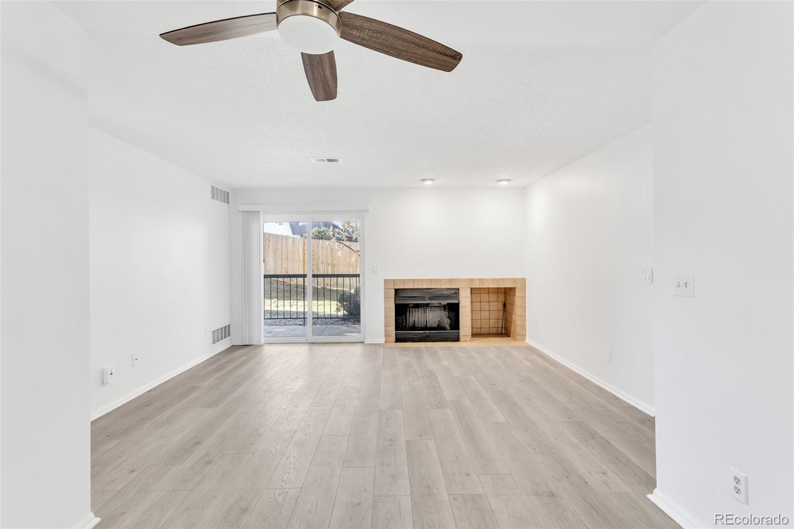 2575 South Syracuse Way, Unit J108 Denver, CO 80231 - Photo 9 of 18 a view of an empty room with a fireplace and a window
