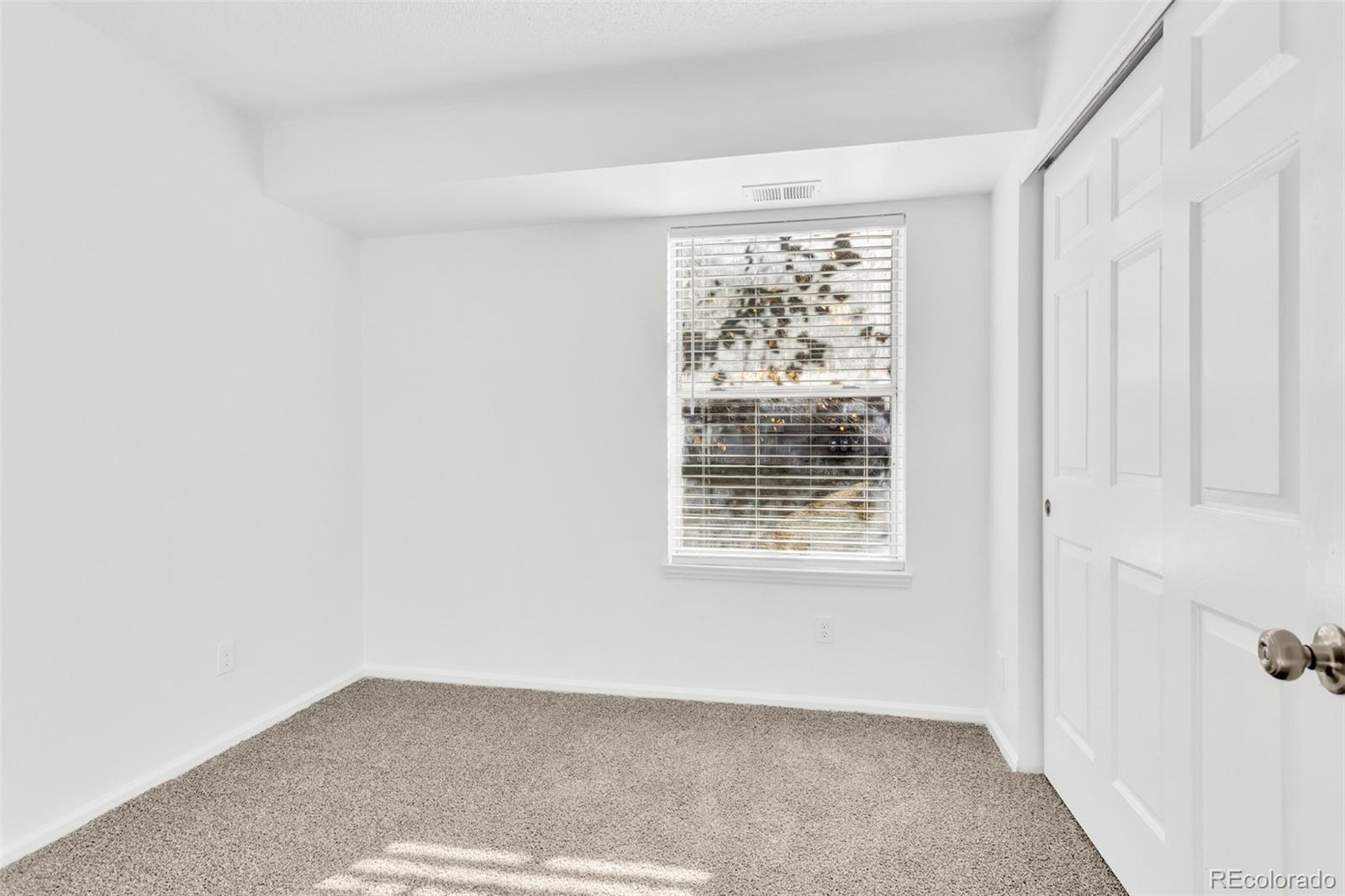 2575 South Syracuse Way, Unit J108 Denver, CO 80231 - Photo 10 of 18 a view of an empty room with a window