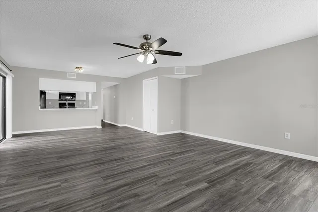 a view of a room with wooden floor and ceiling fan