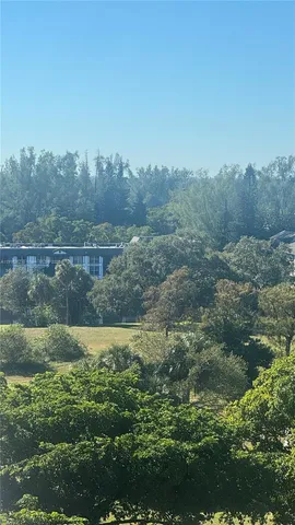 a view of a lake with green field and trees