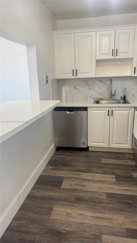 a kitchen with granite countertop white cabinets and white appliances