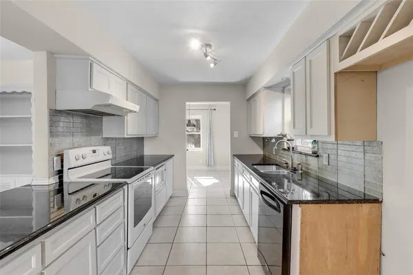 a kitchen with stainless steel appliances granite countertop a sink stove and cabinets