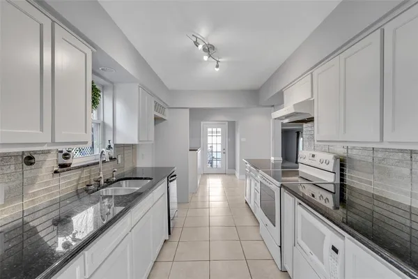 a large kitchen with stainless steel appliances granite countertop a sink stove and cabinets