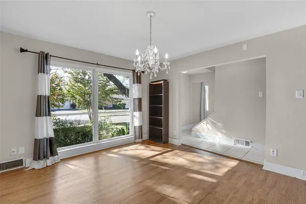 a view of a room with wooden floor large windows and chandelier