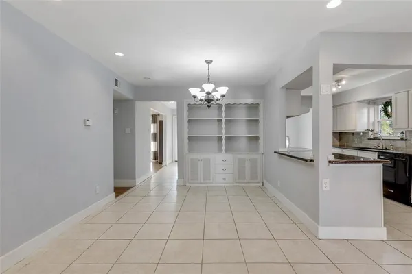 a large white kitchen with a fireplace and cabinets