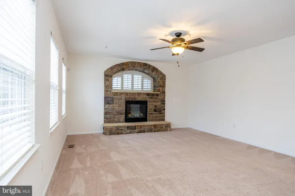 a large kitchen with a large counter top a sink stainless steel appliances and cabinets
