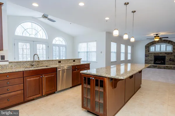 a large kitchen with stainless steel appliances kitchen island granite countertop a sink and a refrigerator