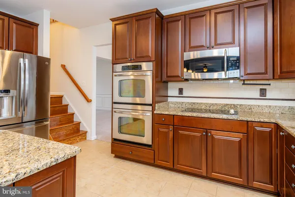 a kitchen with stainless steel appliances granite countertop a sink and a stove