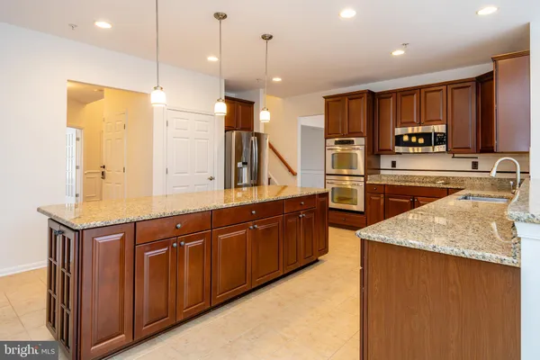 a large kitchen with a large counter top appliances and cabinets