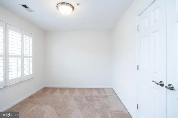 an empty room with a window and a ceiling fan
