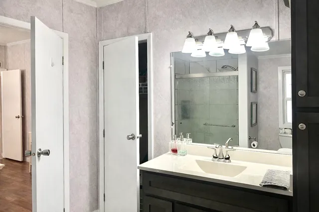 a bedroom with a large bed and a chandelier