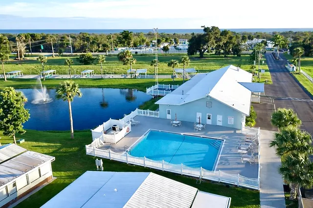 a dining room with furniture and a chandelier fan