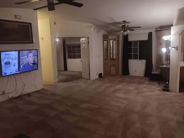 an empty room with projector and fan
