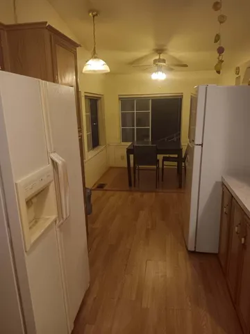 a view of kitchen with refrigerator microwave and wooden floor