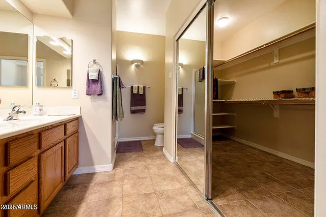 a spacious bathroom with a sink a toilet a mirror and shower