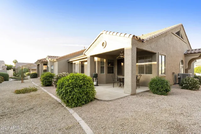 a front view of a house with a garden and plants