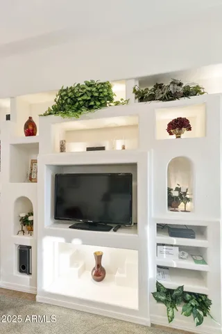 a living room with furniture kitchen view and a chandelier