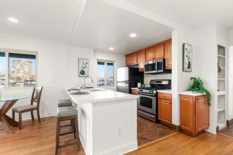 a kitchen with stainless steel appliances a stove a sink a microwave a dining table and chairs