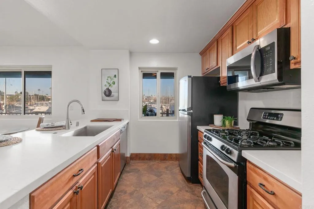 1202 North Pacific Street, Unit 101B Oceanside, CA 92054 - Photo 20 of 48 a kitchen with stainless steel appliances granite countertop a sink stove and cabinets