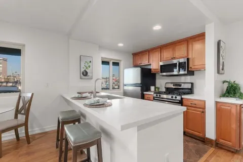 a kitchen that has a sink a counter space and stainless steel appliances