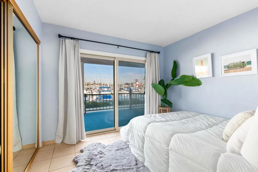 1202 North Pacific Street, Unit 101B Oceanside, CA 92054 - Photo 24 of 48 a bedroom with a bed potted plant and a window