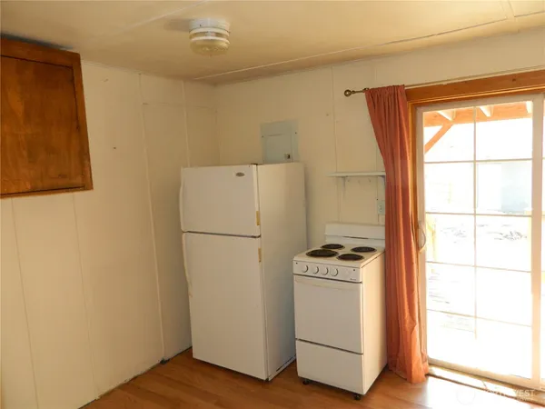 a white refrigerator freezer and a wooden floor