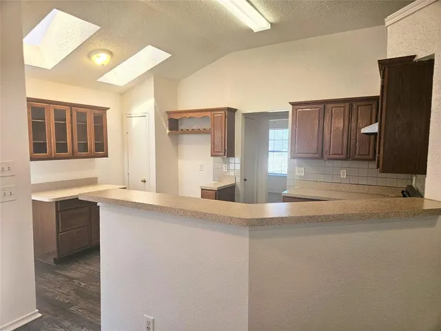 a kitchen with stainless steel appliances granite countertop a sink and a refrigerator