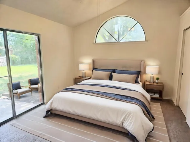 a bedroom with a bed a rug and a large window
