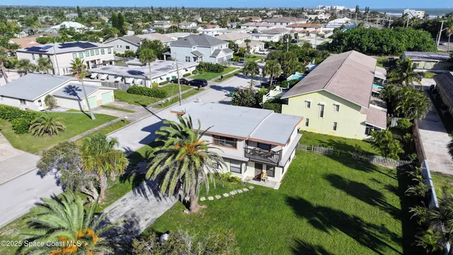 an aerial view of residential houses with outdoor space and parking