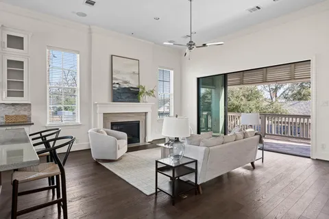 a living room with furniture a large window and a fireplace
