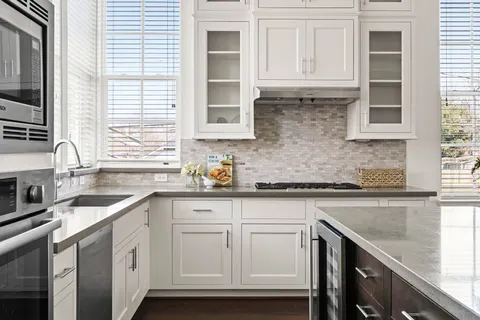 a kitchen with granite countertop white cabinets and white appliances