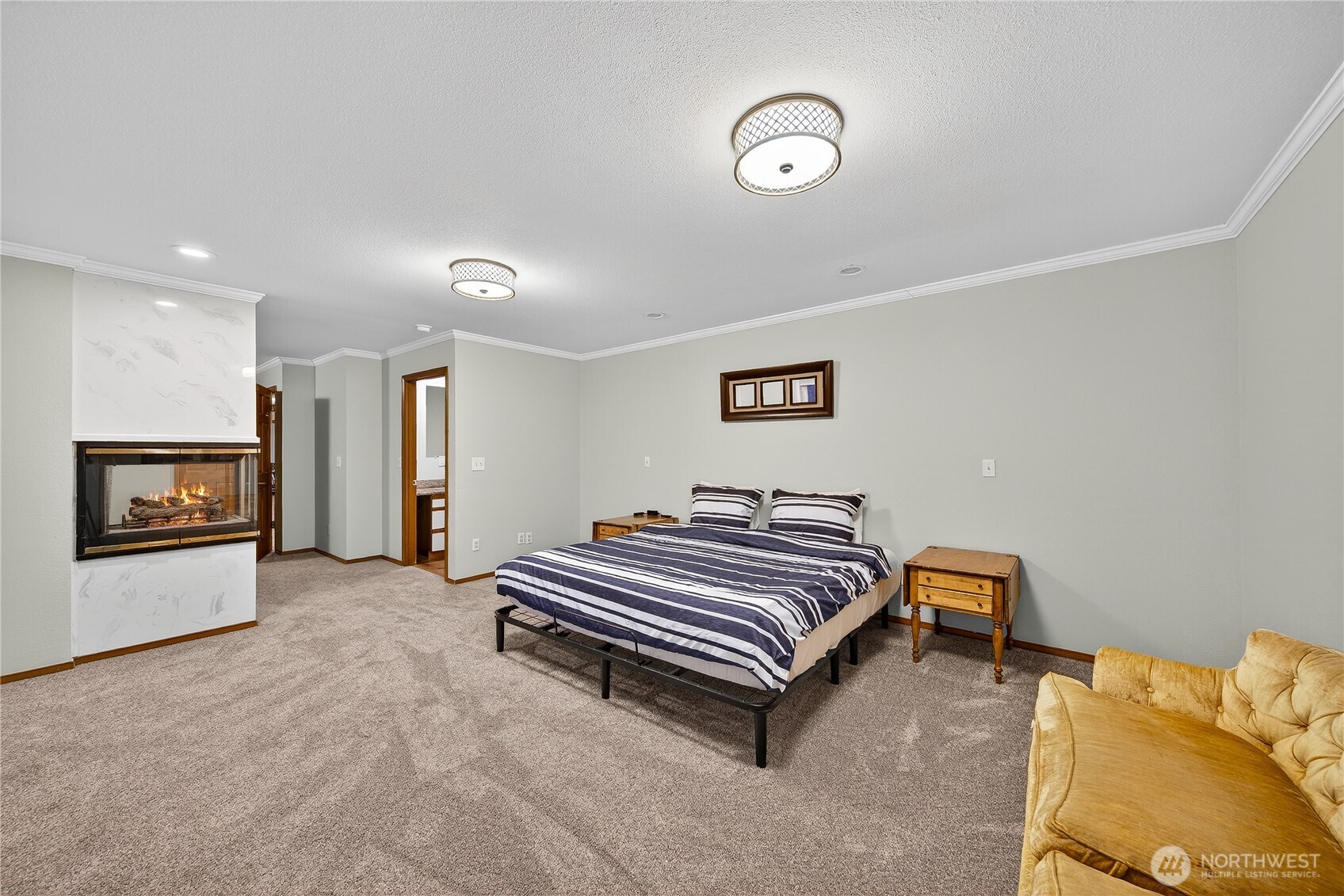 5972 Hastings Road Clinton, WA 98236 - Photo 12 of 40 a spacious bedroom with a bed and a chandelier
