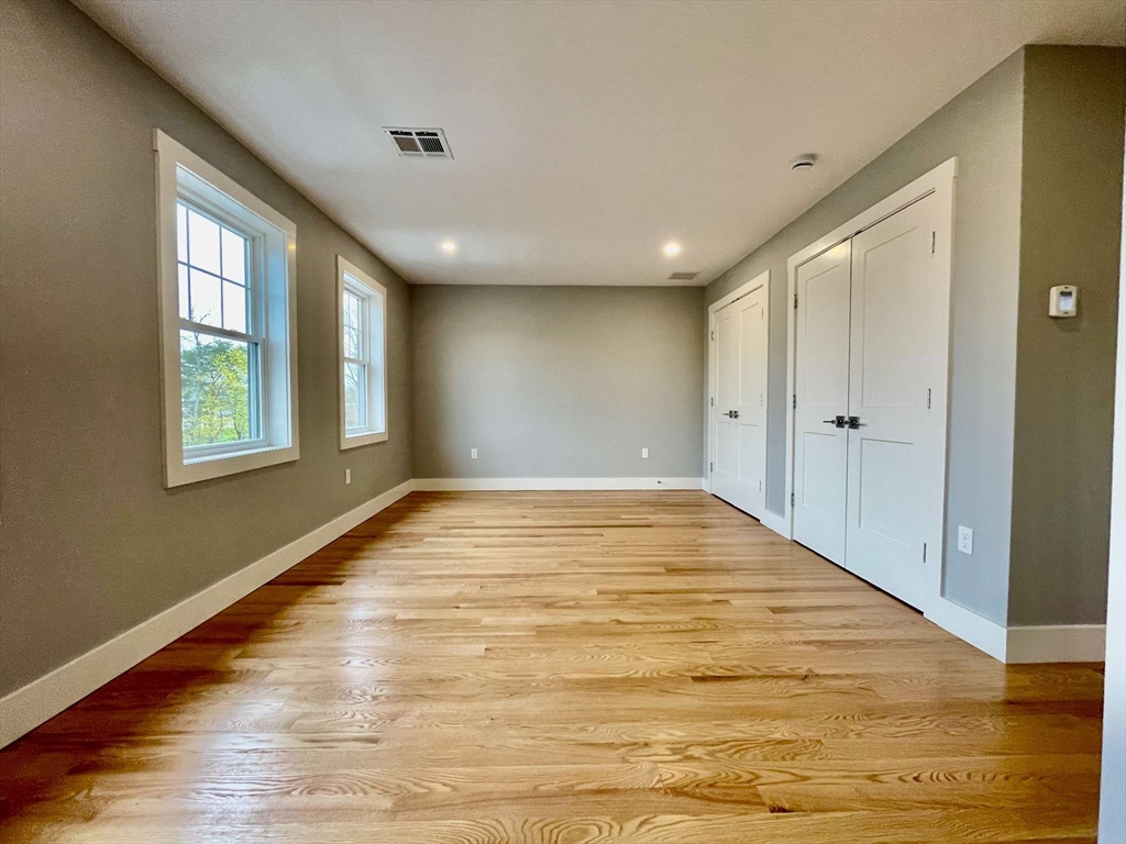 75 Neponset Street, Unit 5 Canton, MA 02021 - Photo 11 of 27 a view of an empty room with wooden floor and a window