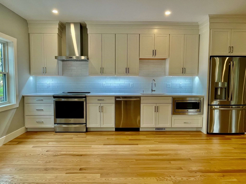 75 Neponset Street, Unit 5 Canton, MA 02021 - Photo 5 of 27 a kitchen with stainless steel appliances kitchen island granite countertop a stove a sink and a refrigerator