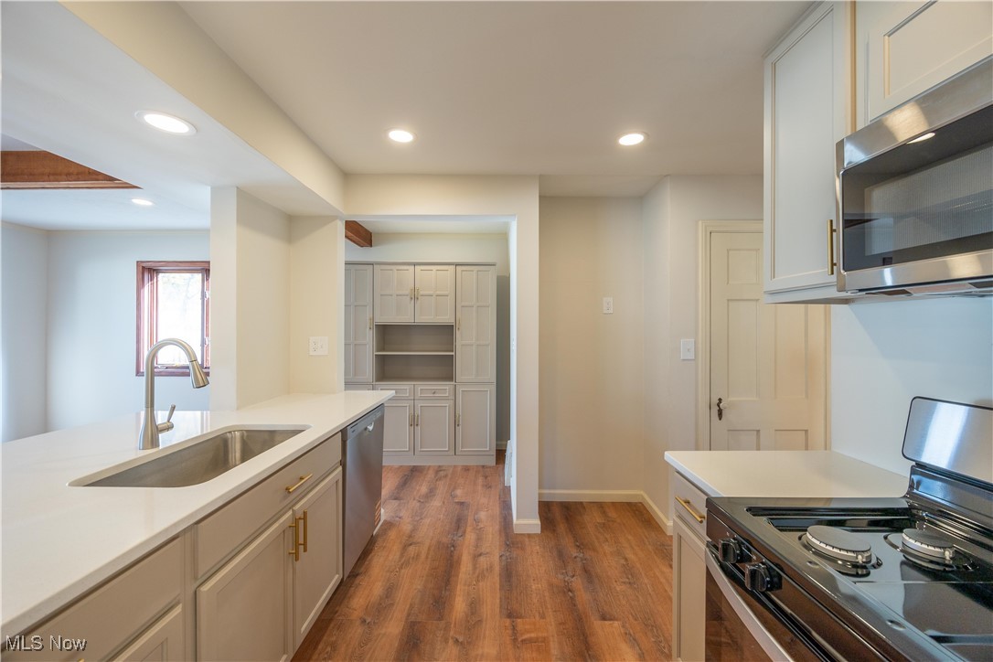 3797 Northwood Road Cleveland, OH 44118 - Photo 17 of 49 Kitchen featuring stainless steel appliances, recessed lighting, dark wood-style flooring, light stone counters, and white cabinets