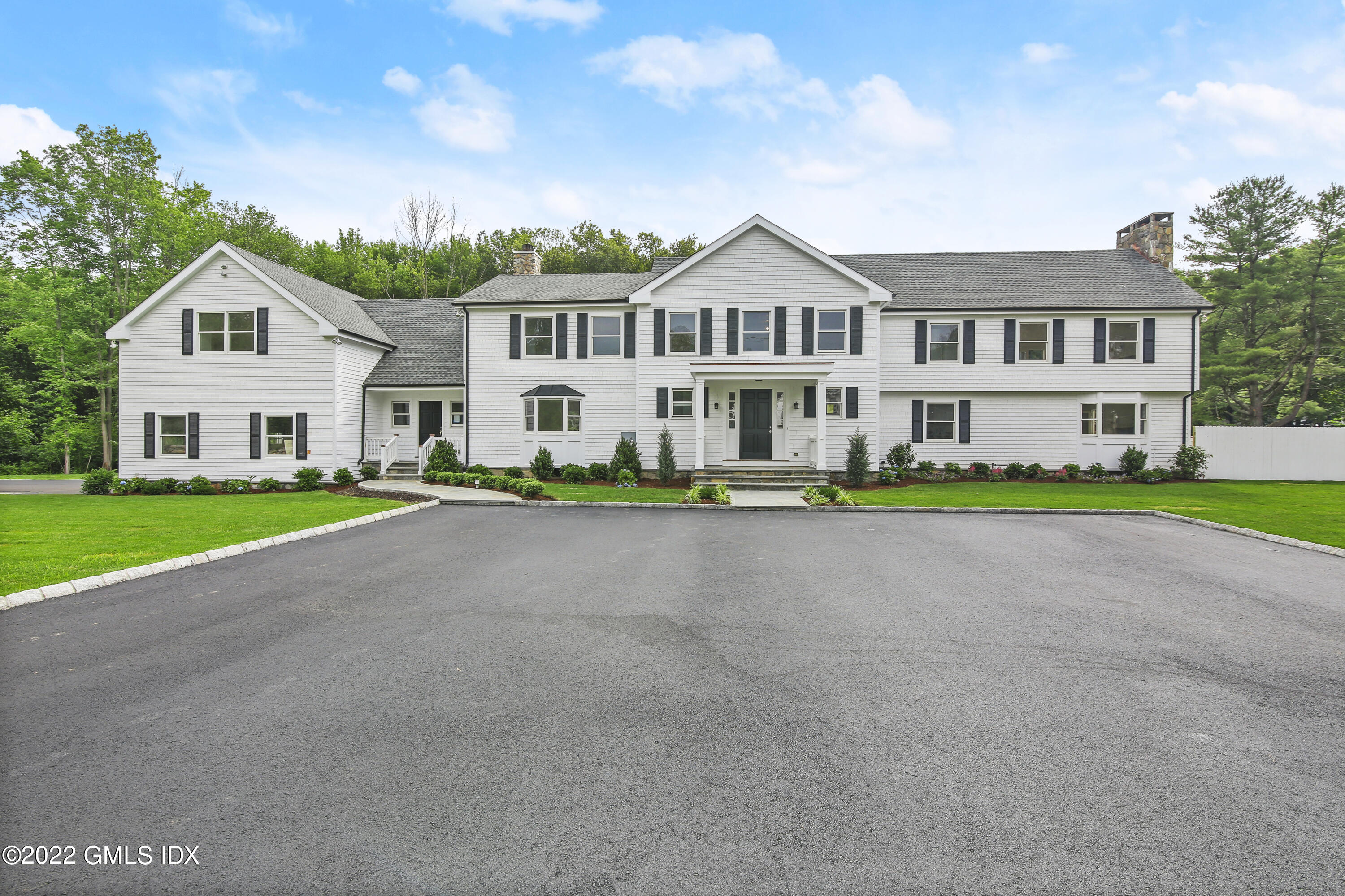 433 Stanwich Road Greenwich, CT 06830 - Photo 2 of 37 a front view of a house with a garden and yard