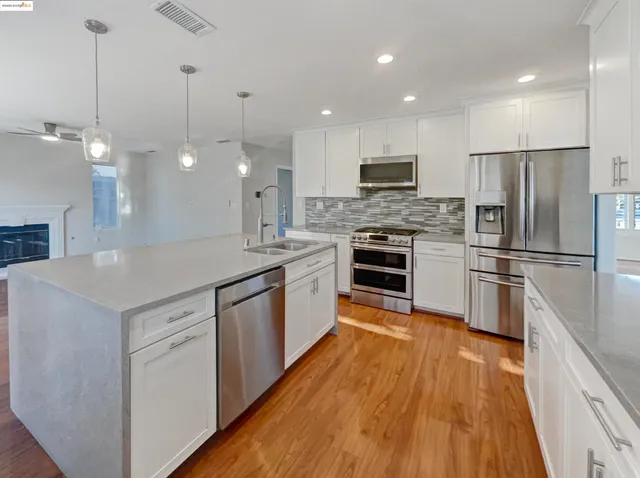 a kitchen with stainless steel appliances granite countertop a sink stove and cabinets