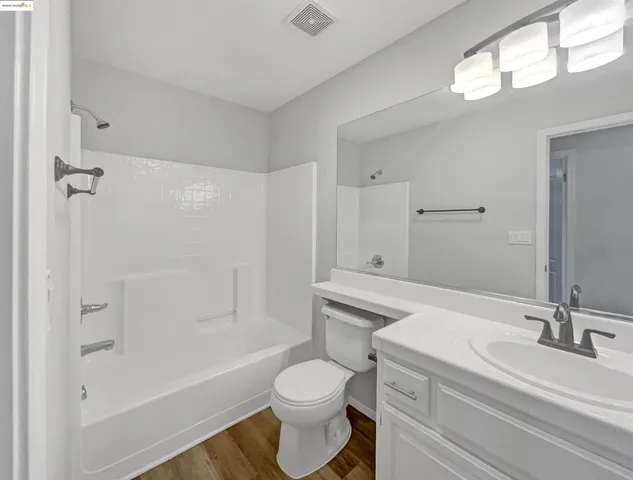 a bathroom with a sink a light fixture and a mirror