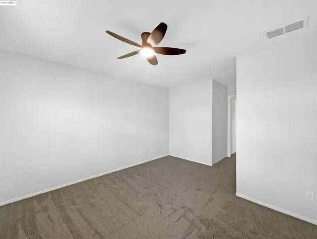 an empty room with window and ceiling fan