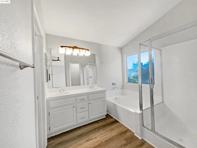 a spacious bathroom with a shower a sink and a mirror