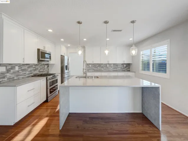 a view of kitchen with cabinets microwave and stove