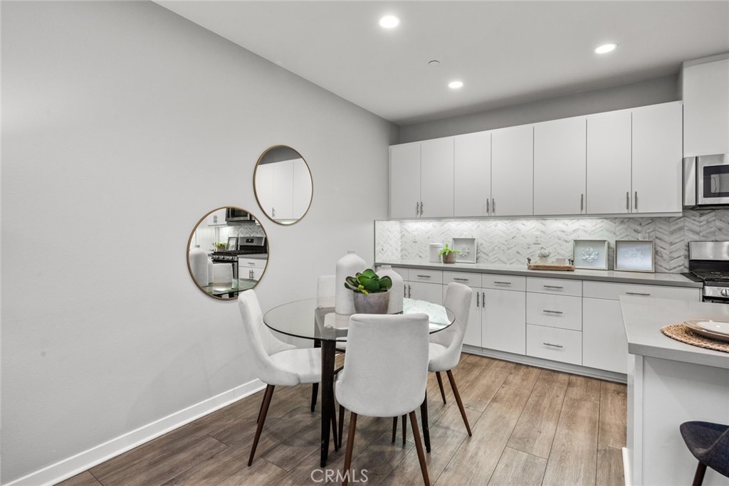 15 Jasmine Lake Forest, CA 92630 - Photo 14 of 44 a kitchen with a dining table chairs and white cabinets