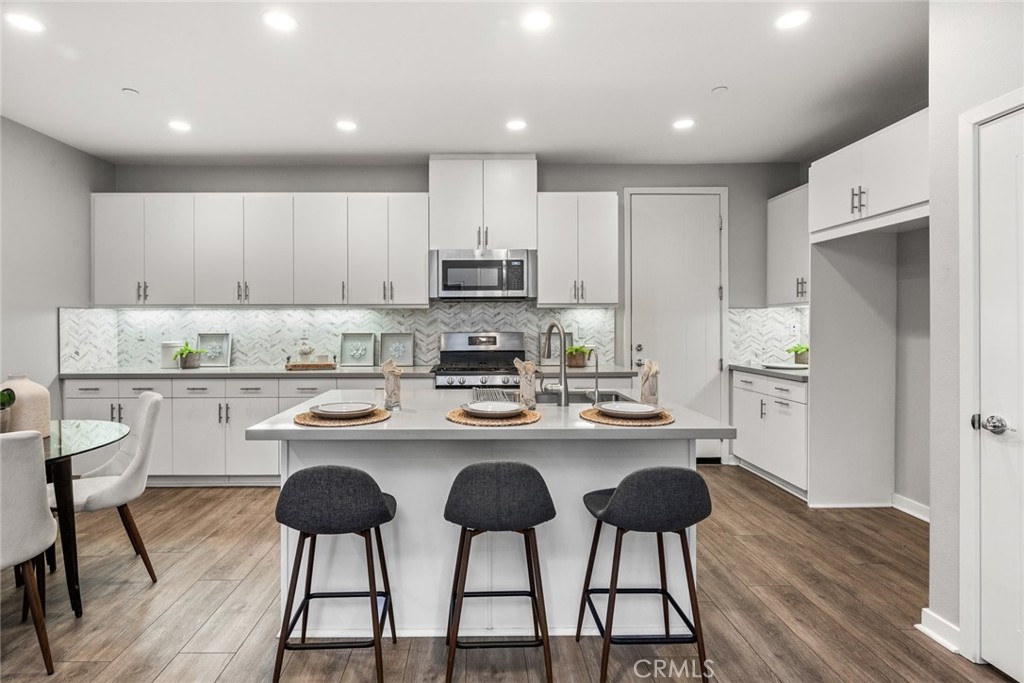 15 Jasmine Lake Forest, CA 92630 - Photo 10 of 44 a kitchen with a dining table chairs refrigerator and cabinets