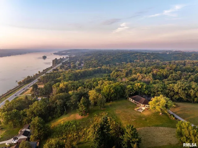 a front view of house with yard and trees in the background