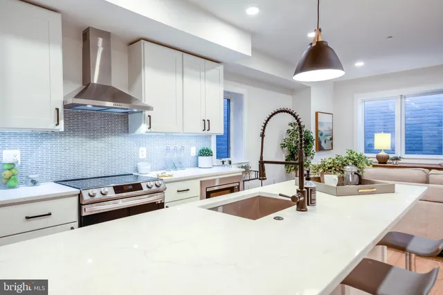 a kitchen with stainless steel appliances a sink a stove and cabinets