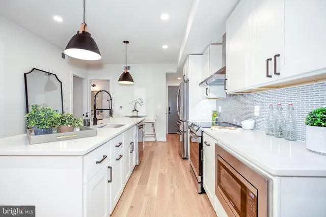 a kitchen with stainless steel appliances a sink stove and cabinets