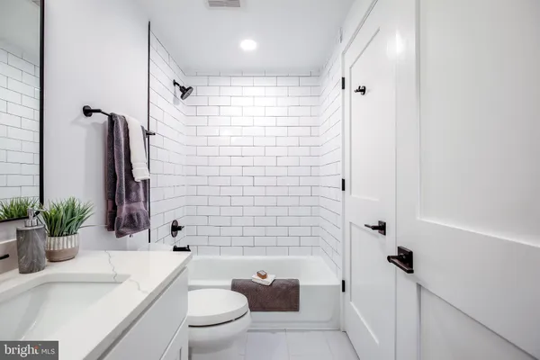 a bathroom with a sink a toilet a tub and shower