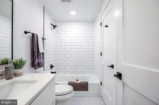 a bathroom with a sink a toilet a tub and shower